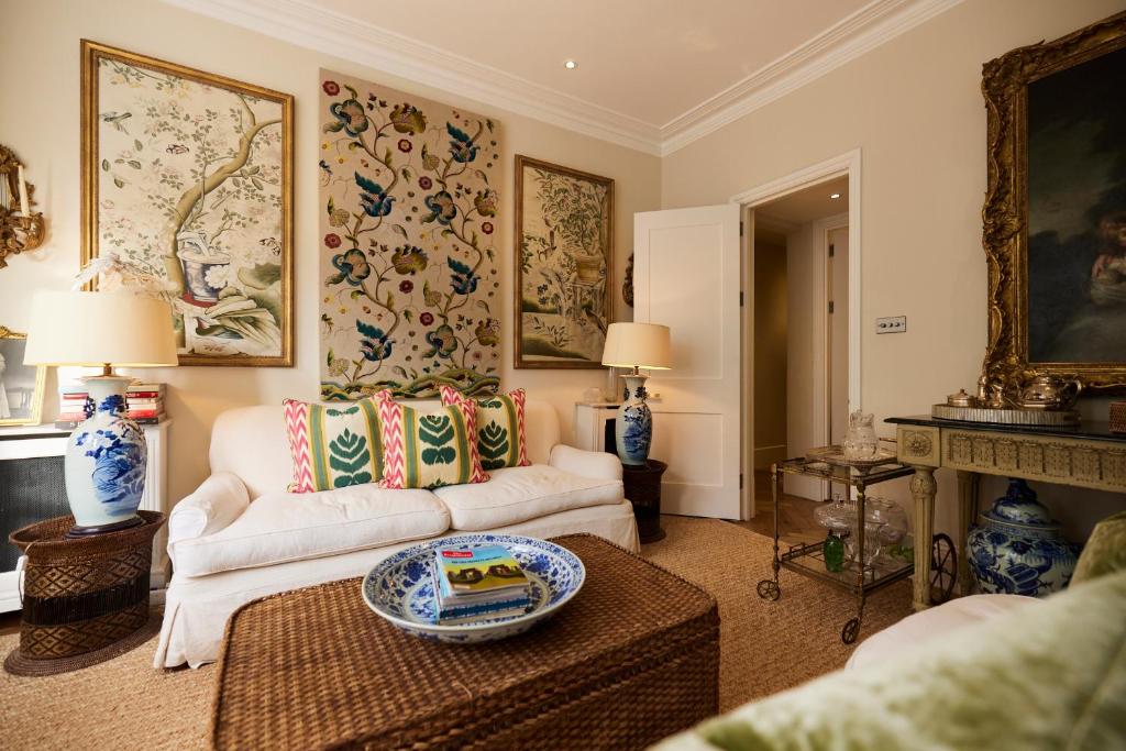 ein Wohnzimmer mit einem Sofa und einem Tisch in der Unterkunft The Kensington Place - Stylish 1BDR Flat in London