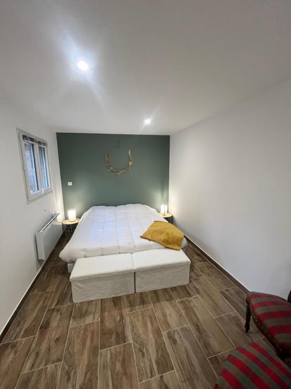 - une chambre avec un lit blanc et du parquet dans l'établissement Chez Mamy, 