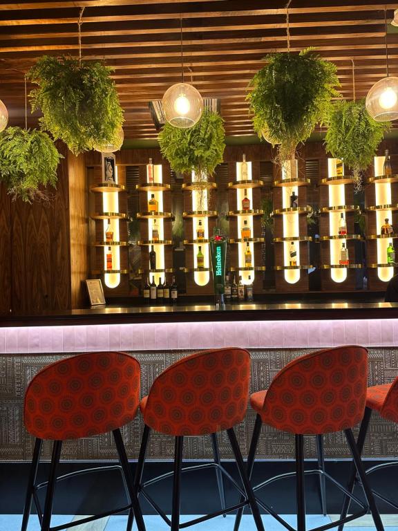 a bar with two red chairs in front of a counter at ONOMO Hotel Johannesburg Sandton in Johannesburg