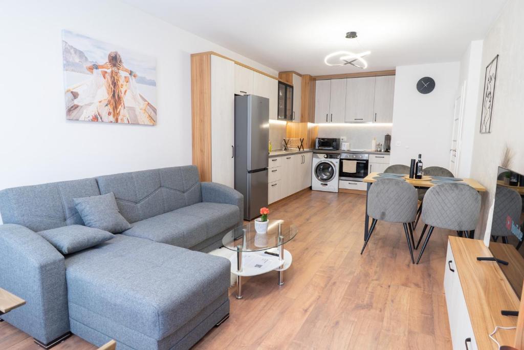 uma sala de estar com um sofá azul e uma cozinha em New Modern & Cozy apartment with FREE Private parking and EV charging station em Varna