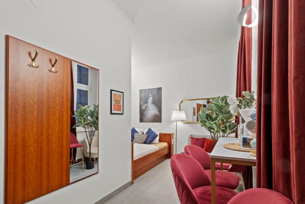 1 dormitorio y sala de estar con sillas rojas. en Central - 30 m² - Next to Augarten, en Viena