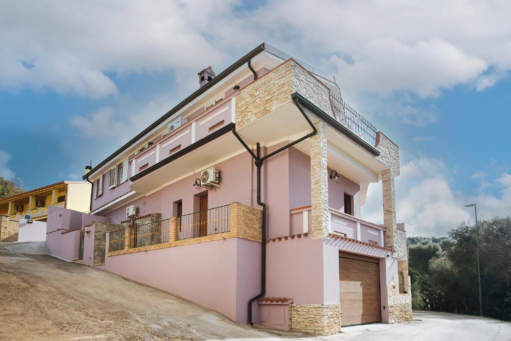 ein rosa Haus auf einer unbefestigten Straße in der Unterkunft Sardinia's house IUN R5500 in Gonnesa
