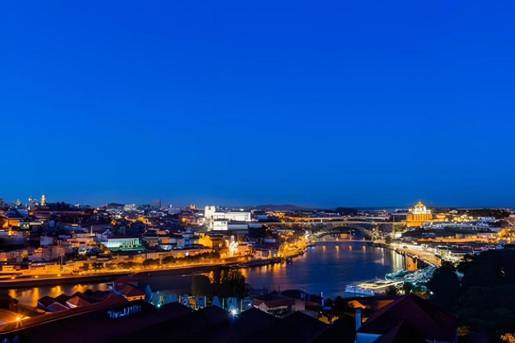 a view of a city with a river at night at Stunning View Apartament by BnbHost in Vila Nova de Gaia