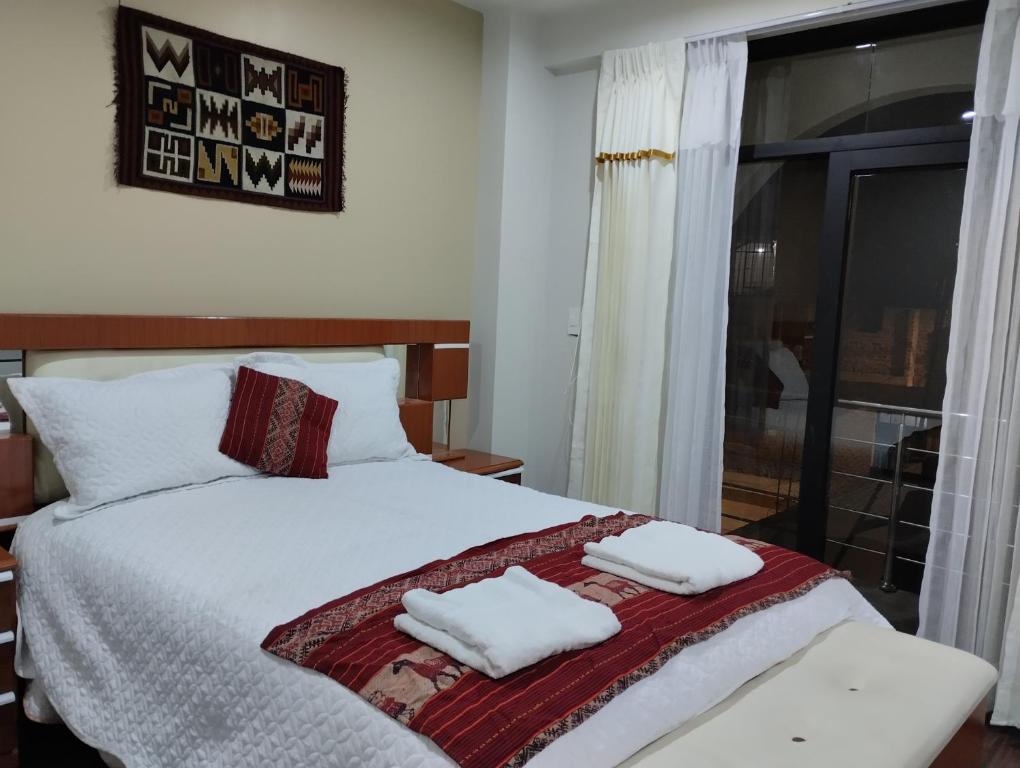 ein Schlafzimmer mit einem Bett mit zwei Handtüchern darauf in der Unterkunft LA CASA REAL in Puno