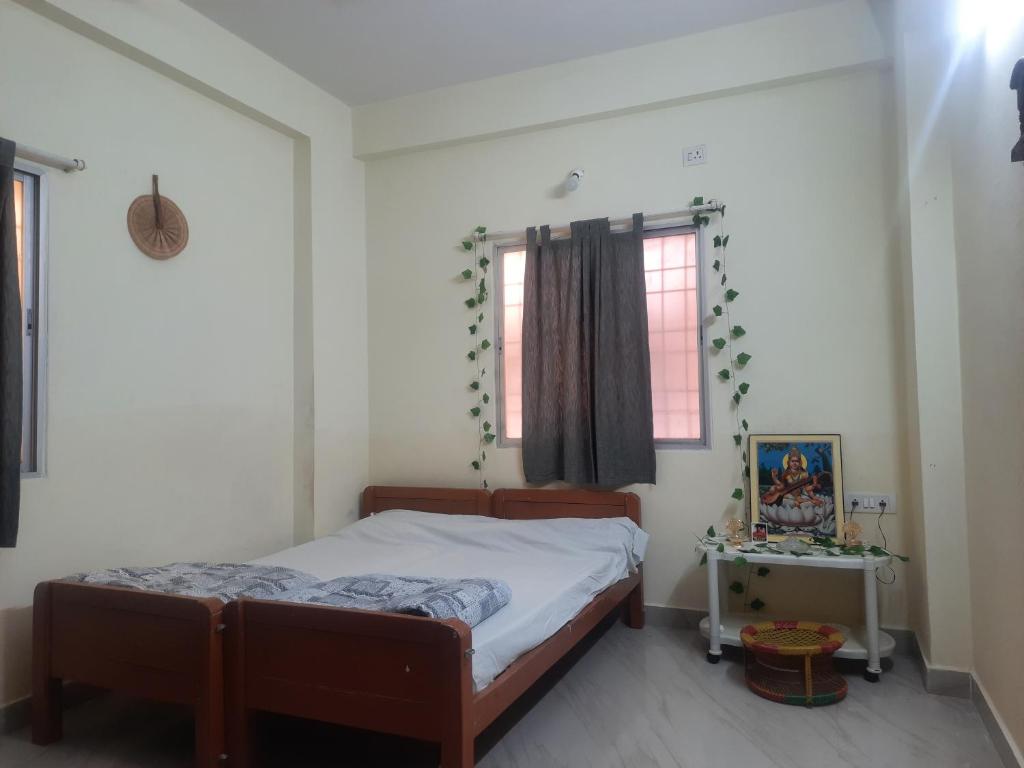 1 dormitorio con cama y ventana en shanthi home, en Puttaparti