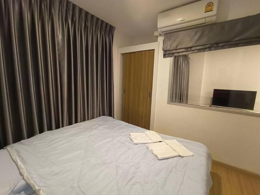 1 dormitorio con 1 cama con 2 toallas en J Condo rama 2, en Bangkok
