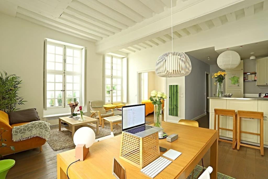 un salon avec une table avec un ordinateur portable dessus dans l'établissement Luxurious Apartment in Le Marais, à Paris