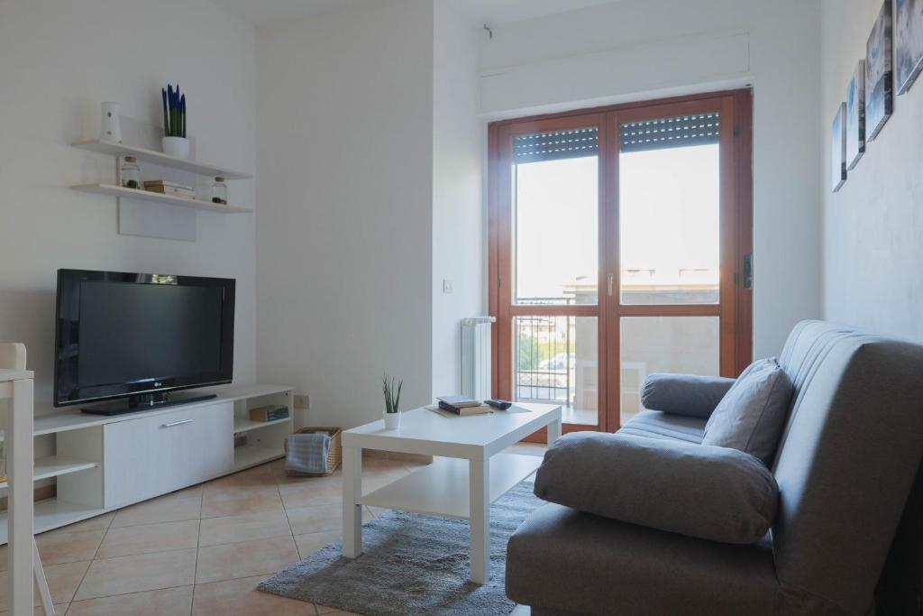 ein Wohnzimmer mit einem Sofa und einem TV in der Unterkunft [Casa Ghandi] 20 min da Roma + Box Auto + Wi-Fi + Self Check-In in Monterotondo