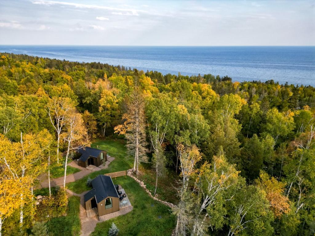 una vista aérea de una cabaña en un bosque con el océano en Tofte Trails en Tofte