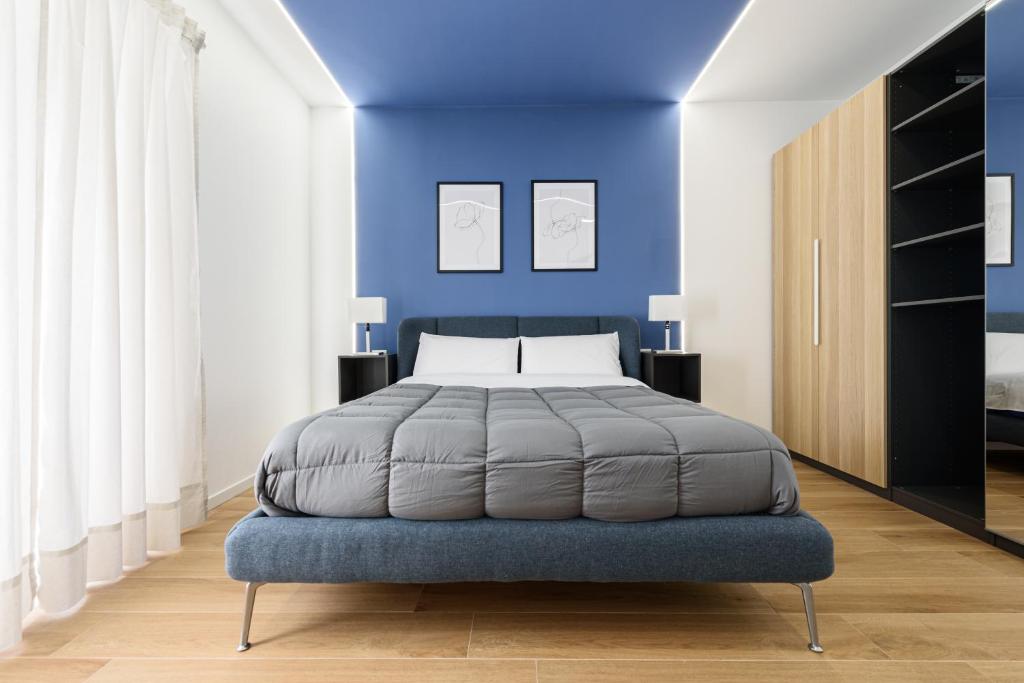 - une chambre avec un lit et un mur bleu dans l'établissement APPARTAMENTI VALLETTI ERCOLANO, à Ercolano