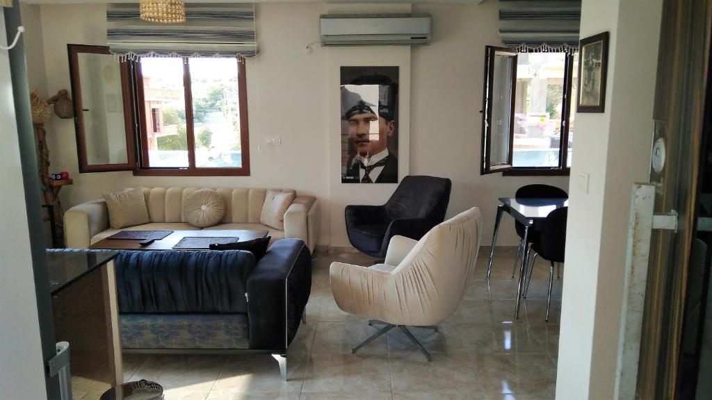 sala de estar con sofá y 2 sillas en Unterkunft mit Blick auf Meer und Berge in Izmir, en Ortaköy