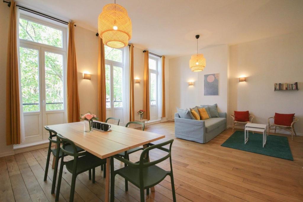 sala de estar con mesa, sillas y sofá en 2-bedroom flat + private car park., en Lille