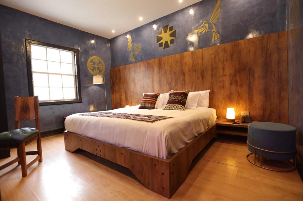 sypialnia z łóżkiem z drewnianą ścianą w obiekcie Chakana Hotel Boutique Mariscal w mieście Quito