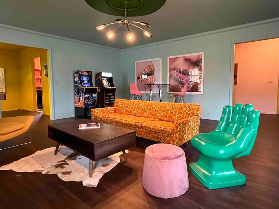 a living room with an orange couch and a green chair at Chic 50s Time Capsule Downtown/OU Med/OK Capitol in Oklahoma City