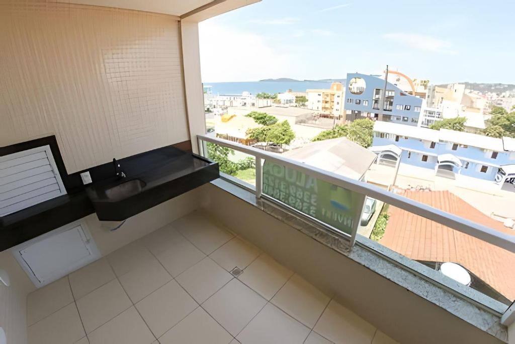 baño con lavabo y balcón con vistas. en Apartamento com vista mar em excelente localização, en Bombinhas