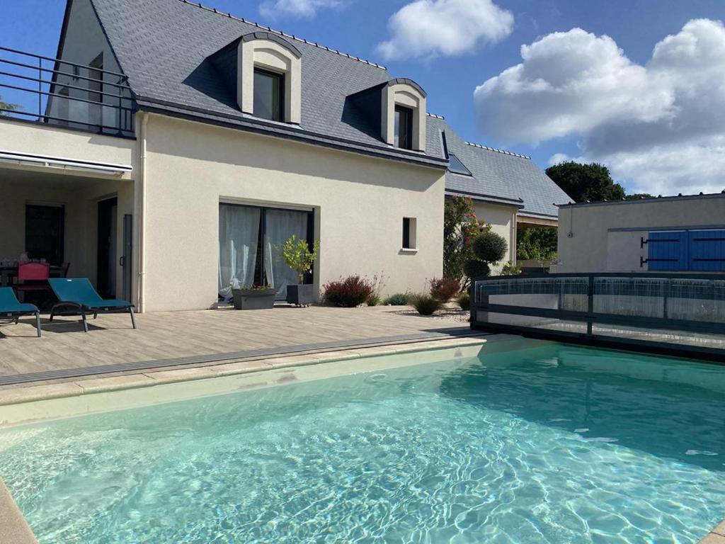 une piscine devant une maison dans l'établissement 803 - Magnifique maison moderne située à Erquy disposant d'une piscine privative, à Erquy