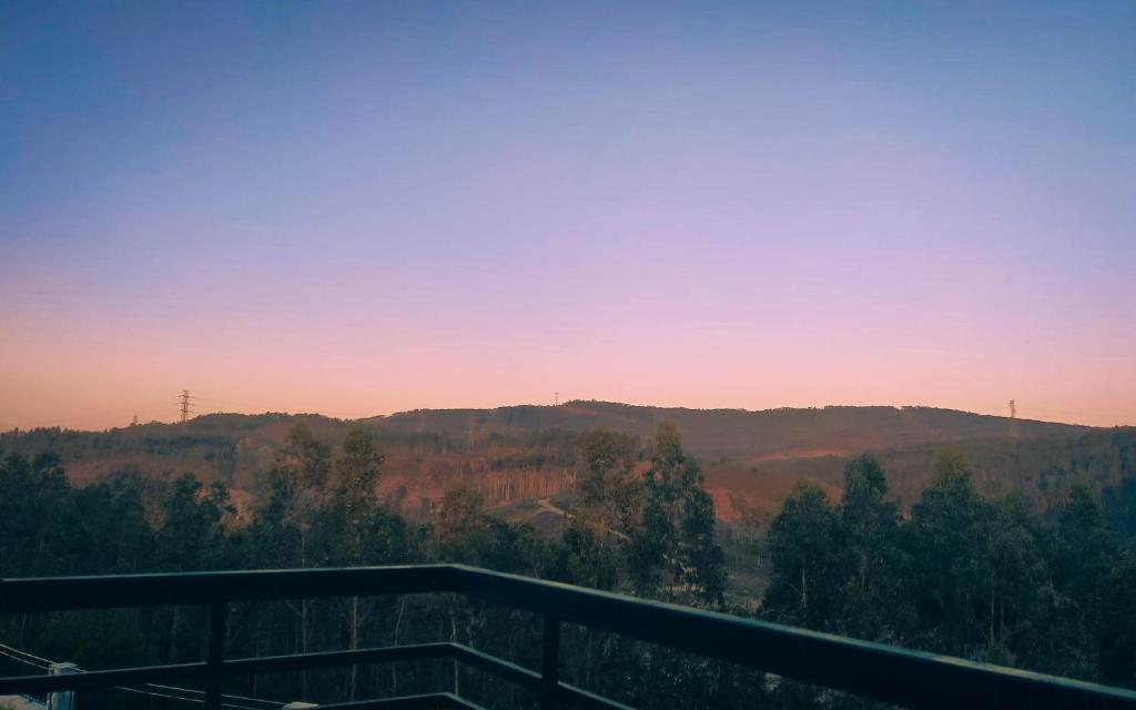 a view of a mountain at sunset from a balcony at Eucalyptus Pink House in Covelo
