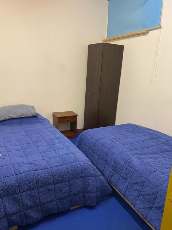 a bedroom with two beds and a cabinet at Comodo departamento in Puerto Montt