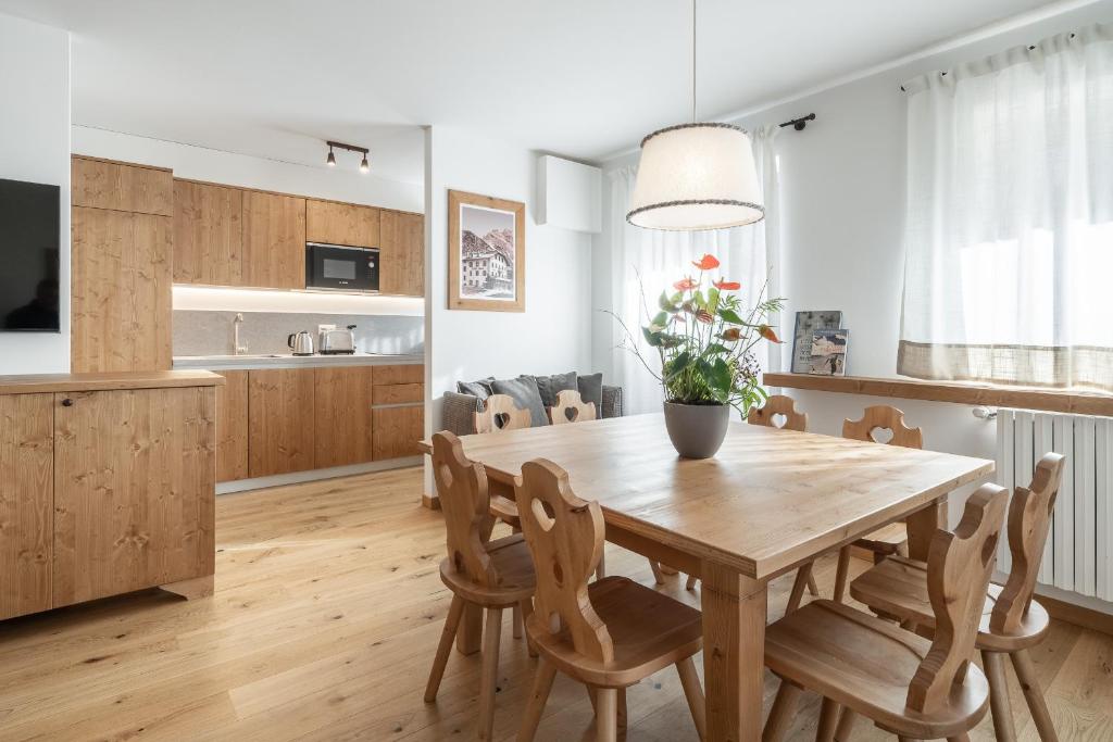 Il comprend une cuisine et une salle à manger avec une table et des chaises en bois. dans l'établissement Chalet Falorie, à Cortina dʼAmpezzo
