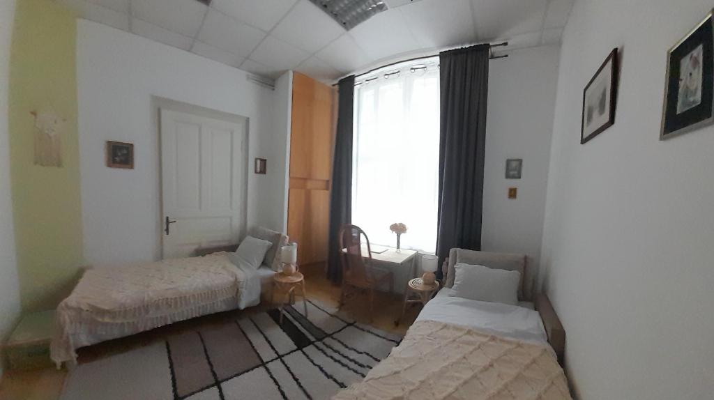 a room with two beds and a large window at Lennon in Vinkovci