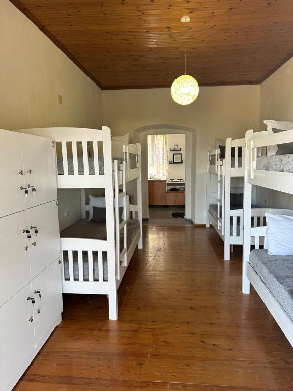 a room with several white bunk beds in it at Hostel on the Hill - by Filikuri Beach in Himare