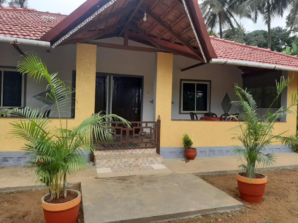 a house with two palm trees in front of it at Sunrise Villa Coorg in Madikeri