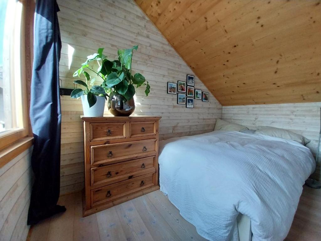 a bedroom with a bed and a dresser with a plant at Huset på berget in Saint-Nizier-du-Moucherotte