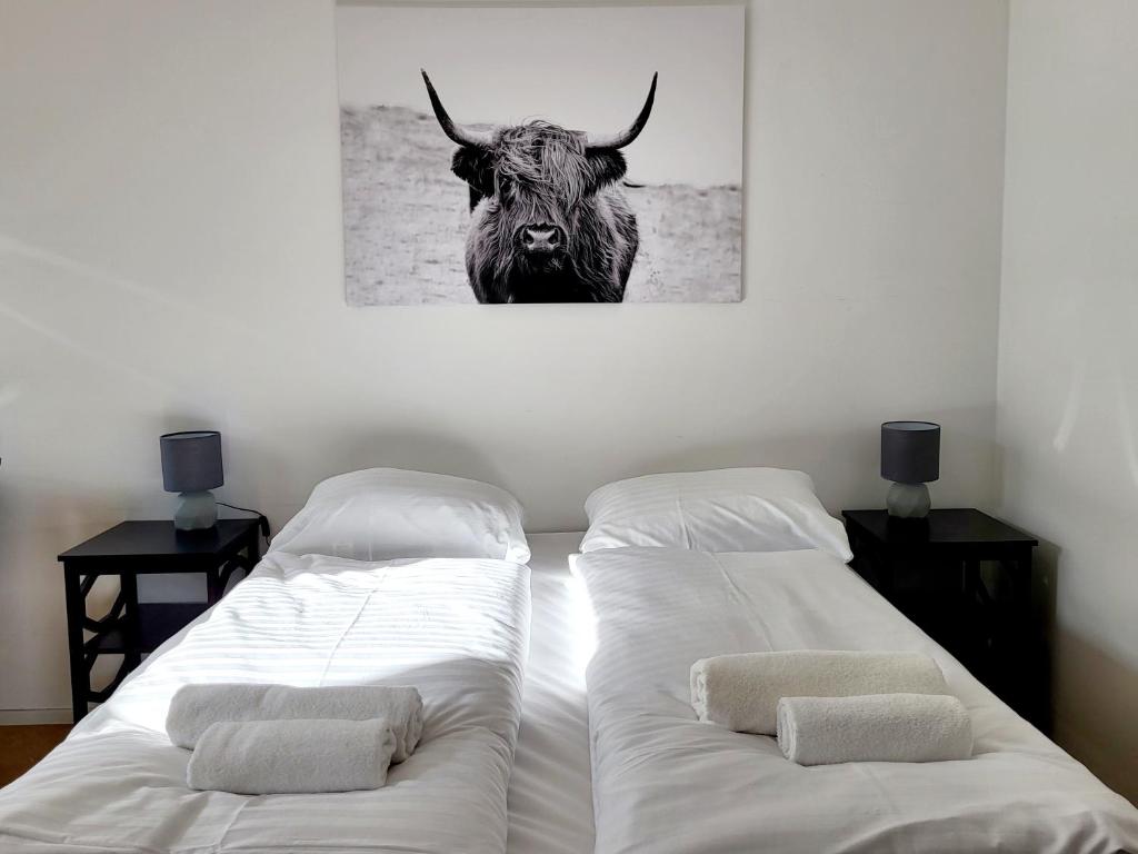 two beds in a room with a picture of a bull at Kienmayer Apartment Vienna in Vienna