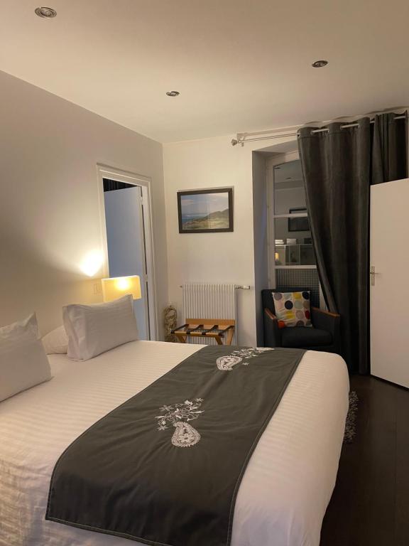 een slaapkamer met een bed met een zwarte deken erop bij Appartement petit déjeuner offert plus ménage in Clermont-Ferrand