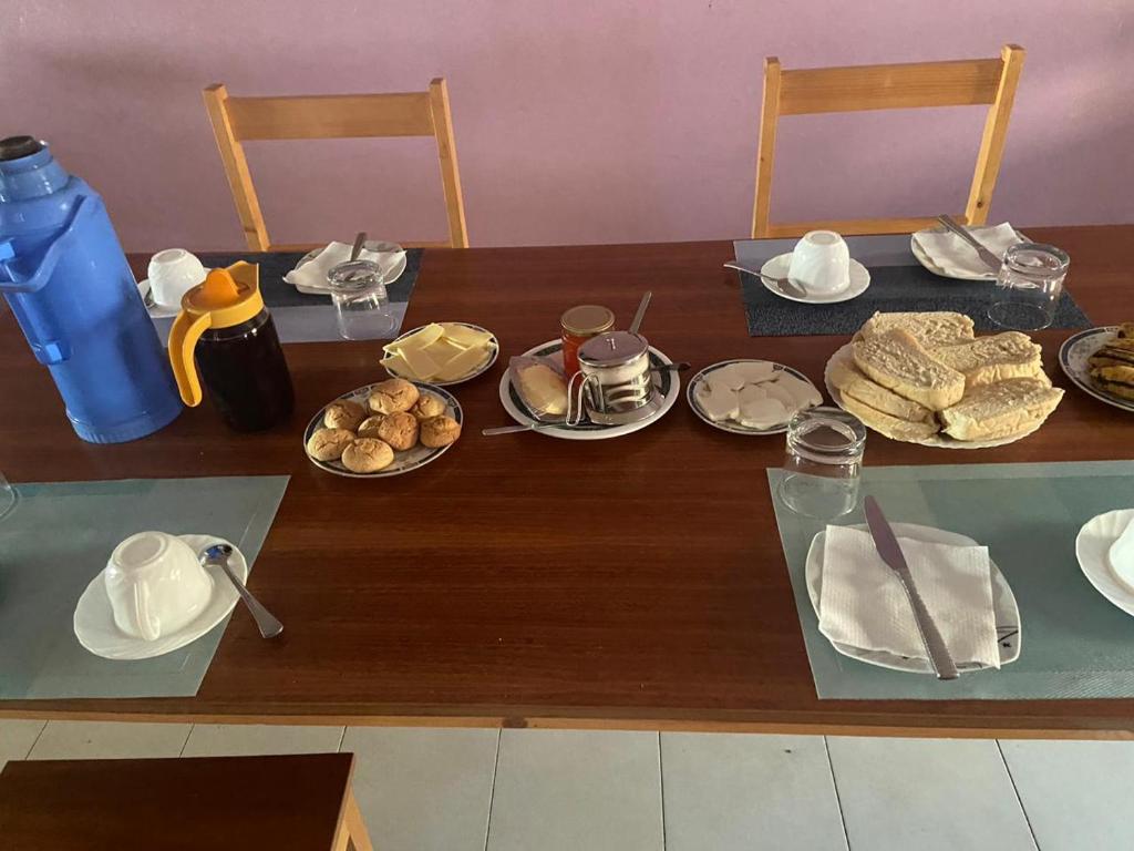a wooden table with plates of food on it at Casa Ze & sonia in Portela