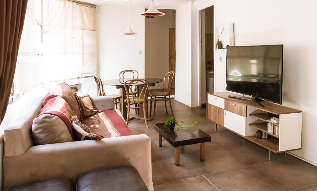 sala de estar con sofá y TV de pantalla plana en Alojamiento Aloja N2 en Mendoza