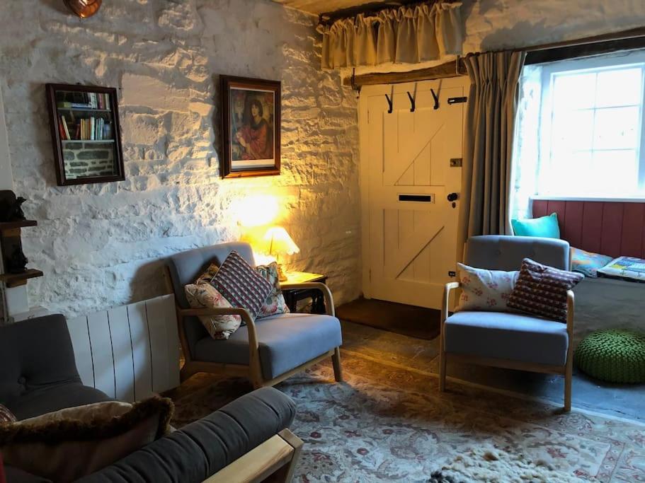 a living room with a couch and chairs and a door at Lavender Cottage, 3 School Road, Clun, Shropshire in Clun