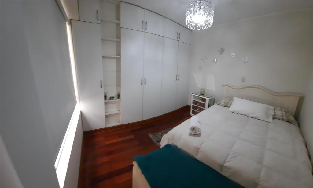um pequeno quarto com uma cama e um lustre em Luz em Lima