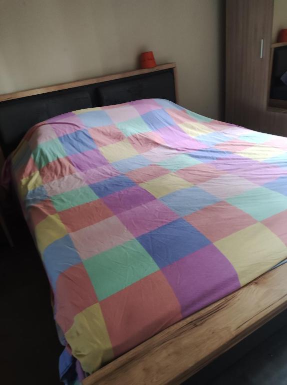 eine bunte Bettdecke auf einem Bett in einem Zimmer in der Unterkunft Appartement 2 chambres étang sale in L’Étang-Salé