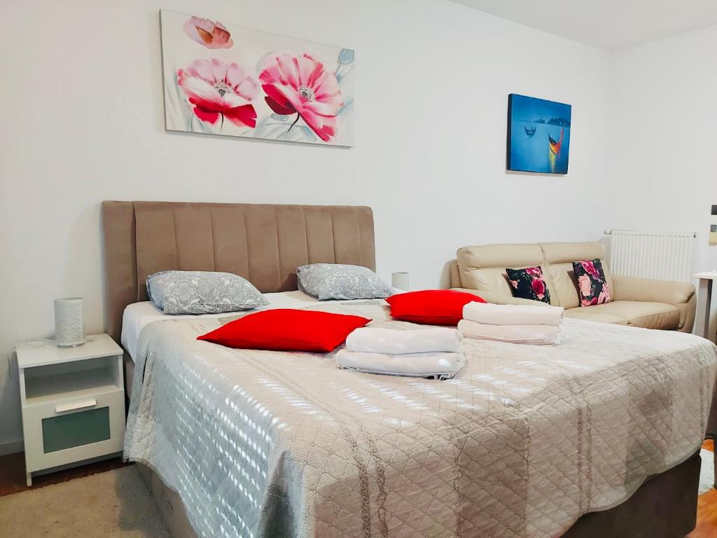 a bedroom with a large bed with red pillows at Nova Galerija West App Mary in Zagreb