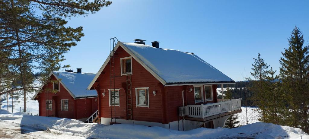 una casa rossa con neve sul tetto di Hallan Alpit A mökki a Hyrynsalmi