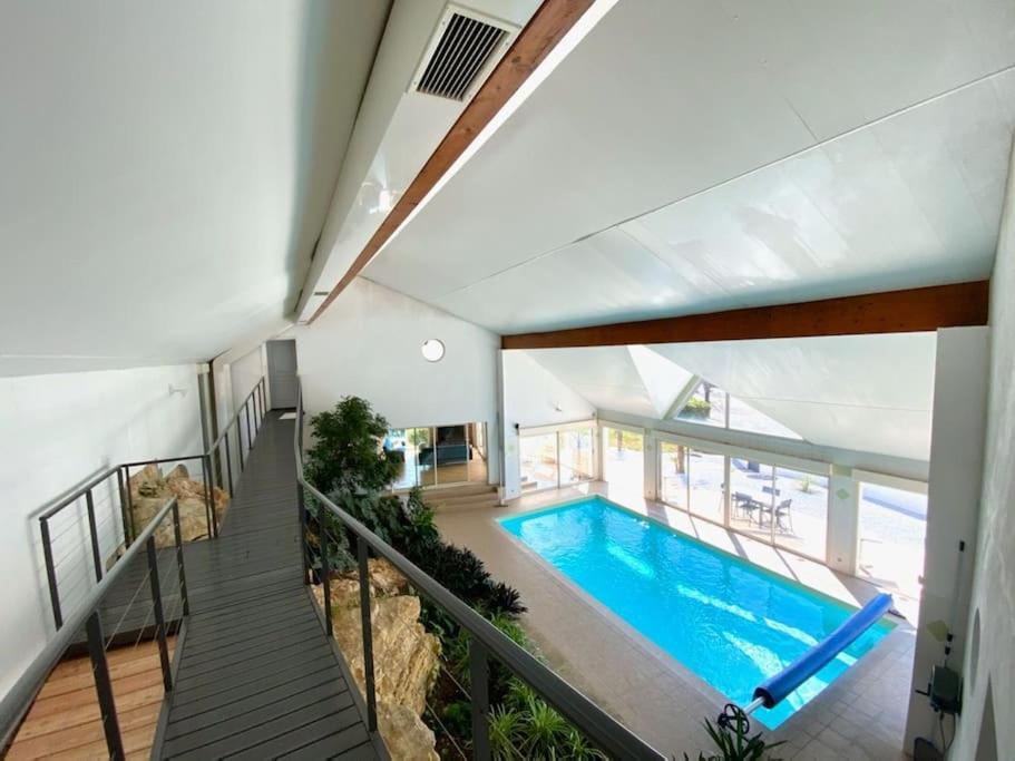 ein großer Pool in einem Haus mit einer Treppe in der Unterkunft Villa avec piscine d'intérieur “ Losalia “ in Talant