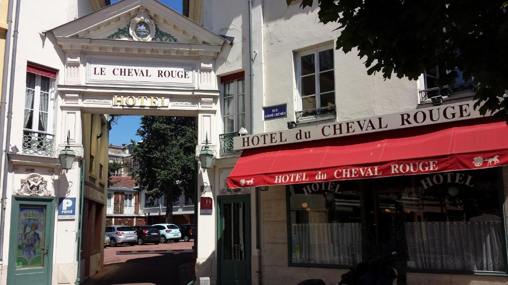 a building with a red awning on a street at Hôtel du Cheval Rouge in Versailles