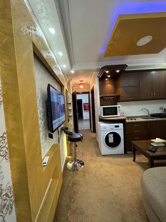 a living room with a television and a kitchen at al-burj apart 7th circle in Amman