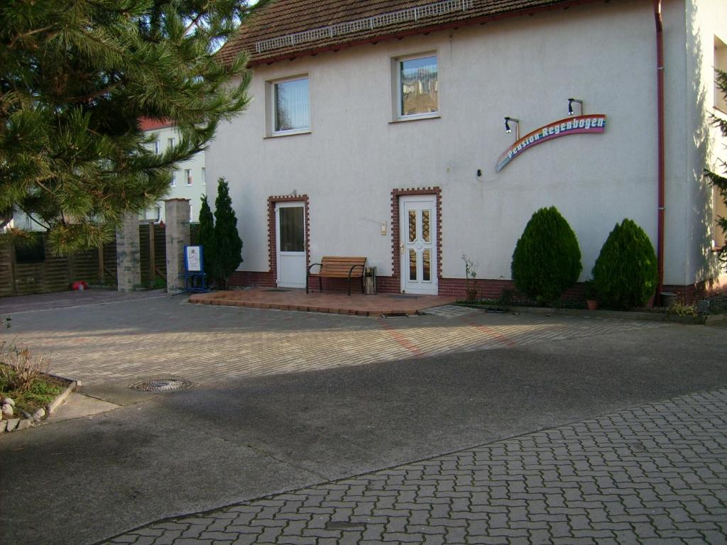 a white building with a sign on the side of it at Pension Regenbogen in Stralsund