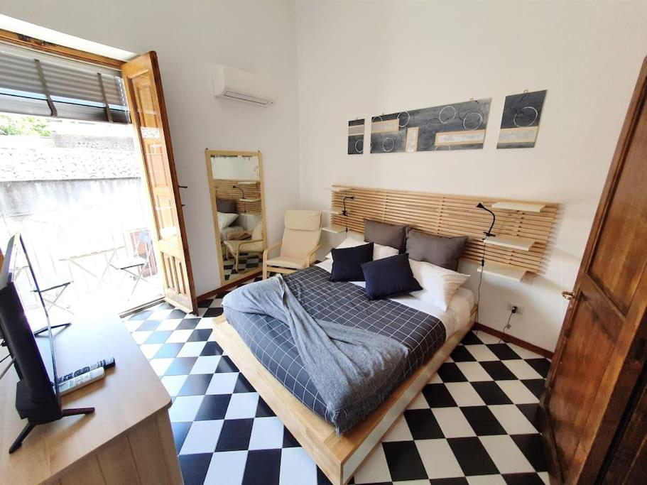 een slaapkamer met een bed, een bureau en een televisie bij Casa vacanze a Nicolosi - Etna - Black and White in Nicolosi