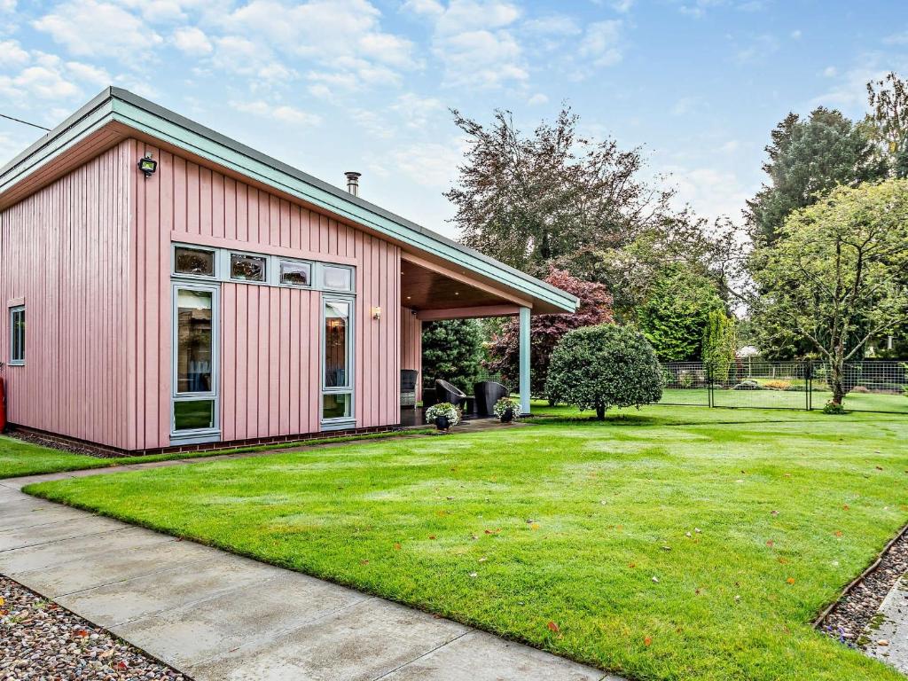 a pink house with a grass yard at 1 Bed in Blairgowrie 93427 in Rattray