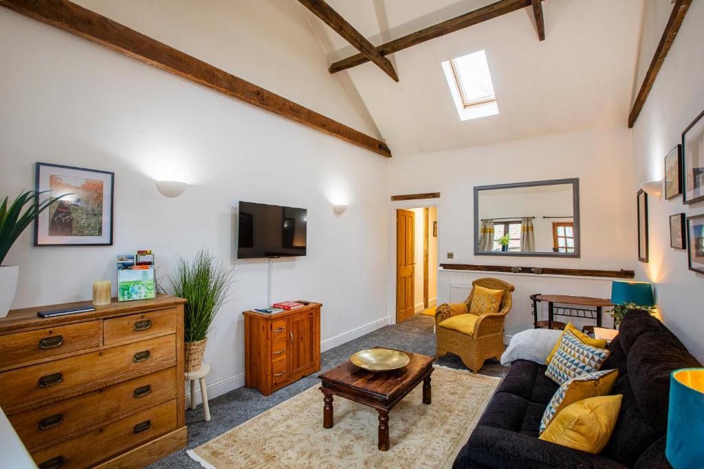 a living room with a couch and a tv at The Carriage House a relaxing 1-Bed Cottage in Ash in Ash