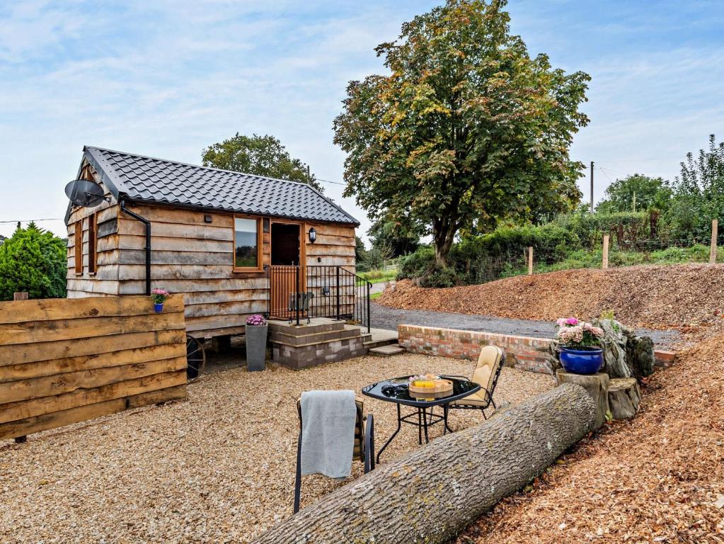 a small wooden cabin with a table and a patio at 1 Bed in Bridport 93355 in Marshwood