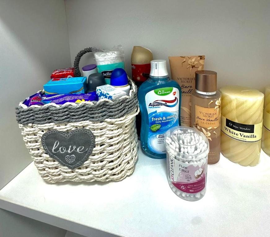 a shelf with a basket and a bottle of soap at Evelyn Apartment in Bistriţa