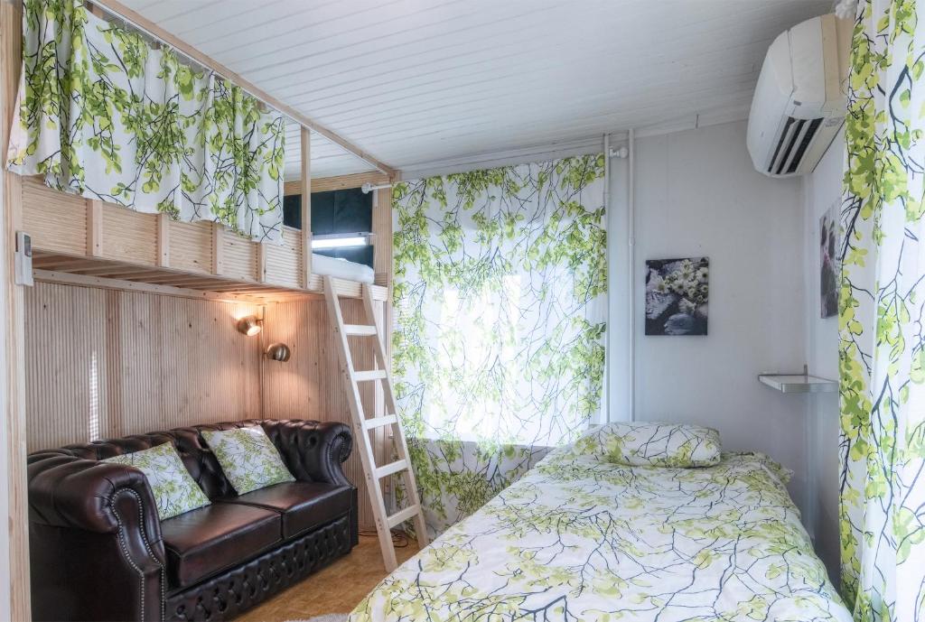 a bedroom with a bunk bed and a couch at Mäkkylän Helmi in Helsinki