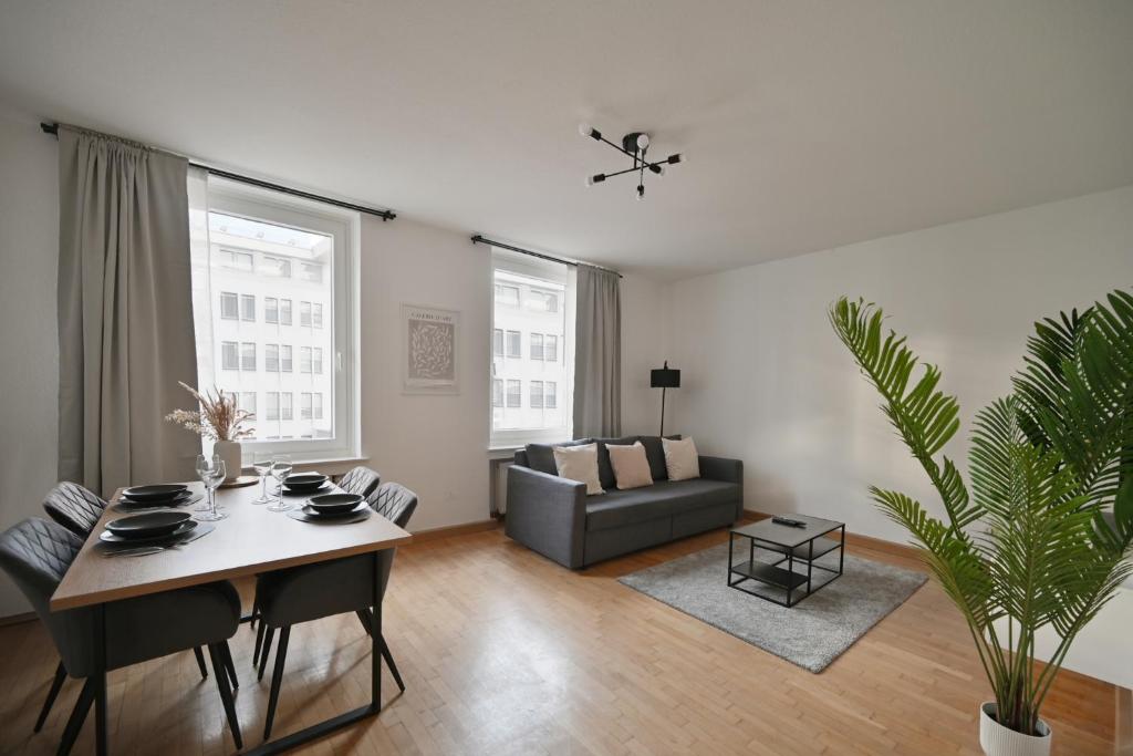 ein Wohnzimmer mit einem Tisch und einem Sofa in der Unterkunft Goodliving Apartments mit Netflix Büro und Parkplatz in Essen