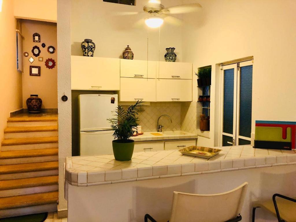 a kitchen with white cabinets and a counter top at Rincón Natural PA in Puerto Aventuras