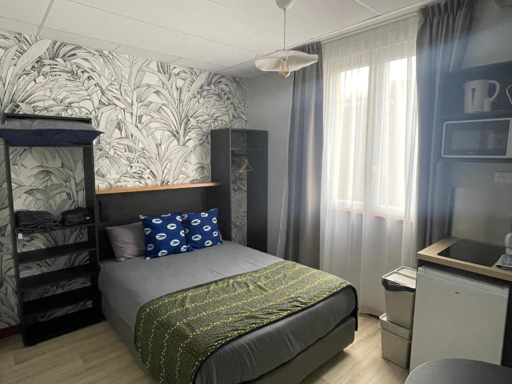 niewielka sypialnia z łóżkiem i malowidłem ściennym w obiekcie Smart Appart Le Havre 97 w Hawrze