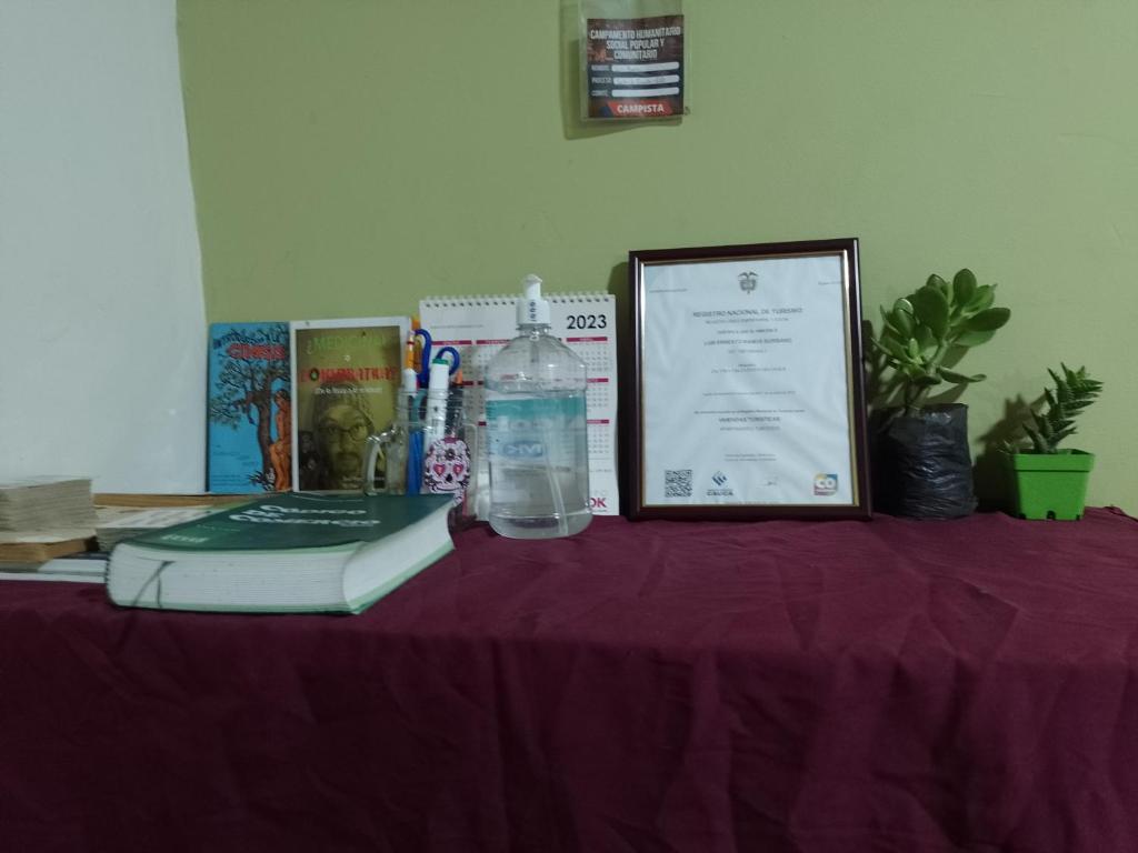 a table with a book and a bottle of water on it at Alojamiento Don Luis in Popayan